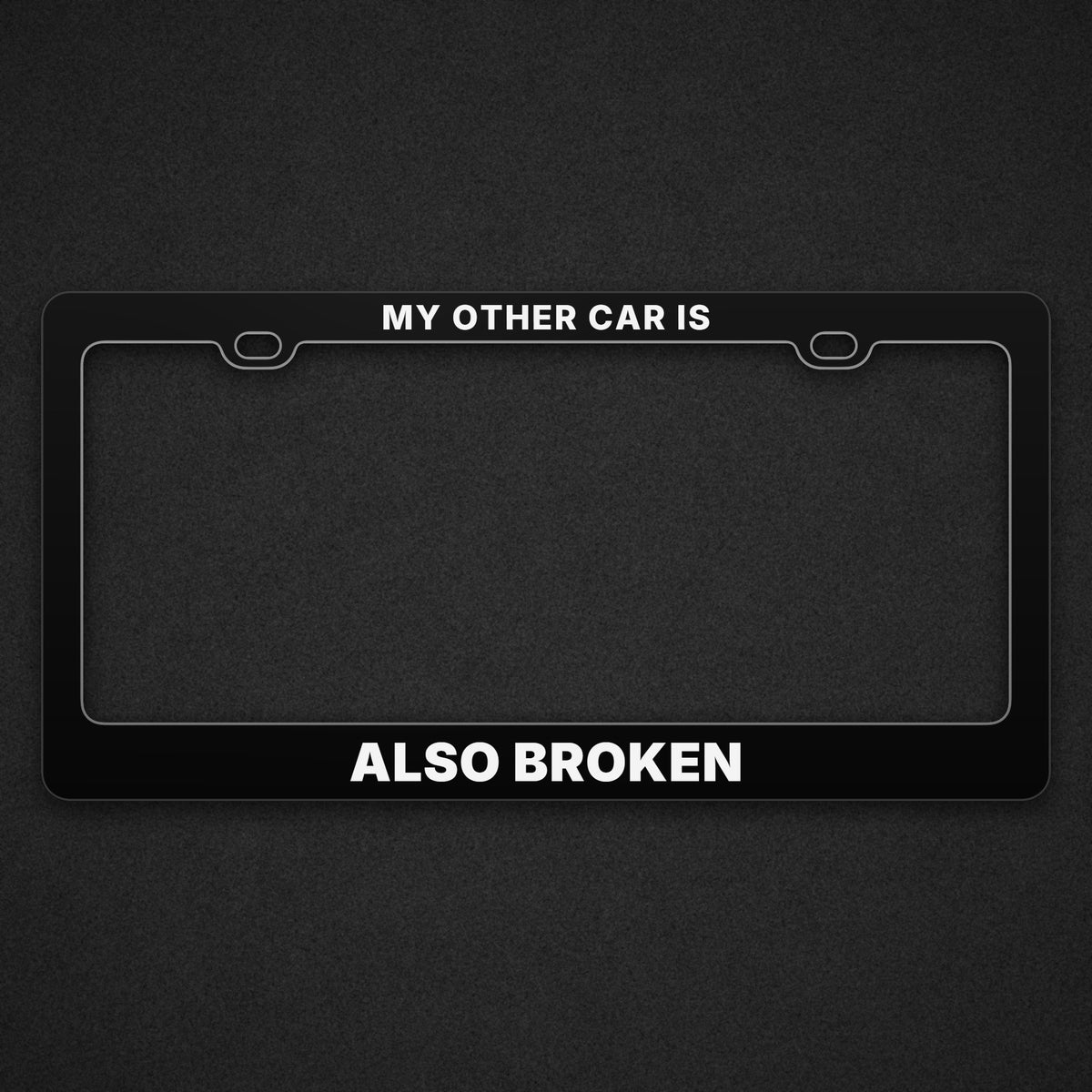 Black ALSO BROKEN plate frame with MY OTHER CAR IS across the top